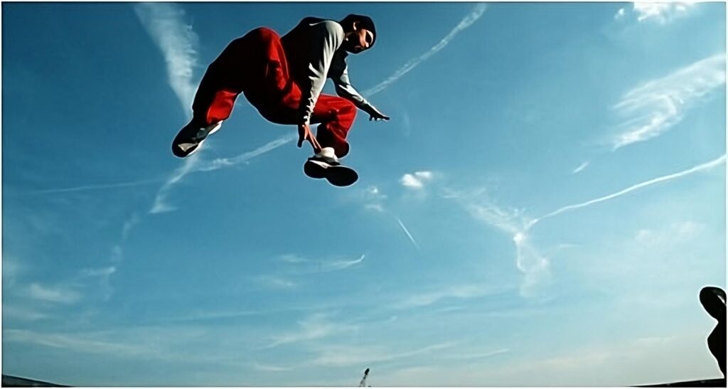 Men jumping in red sweatpants. Parkour jump